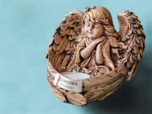 Ángel porta velas . El regalo ideal para tus invitados destacados como padrinos, abuelos, etc... Está realizado a mano en su totalidad. El material empleado para su elaboración es yeso y betún de Judea para la pátina final que le da un acabado elegante y atemporal . Medidas aproximadas: 18cm de altura y 40 cm de diámetro. Incluye una vela de te. Precio: 18,50€