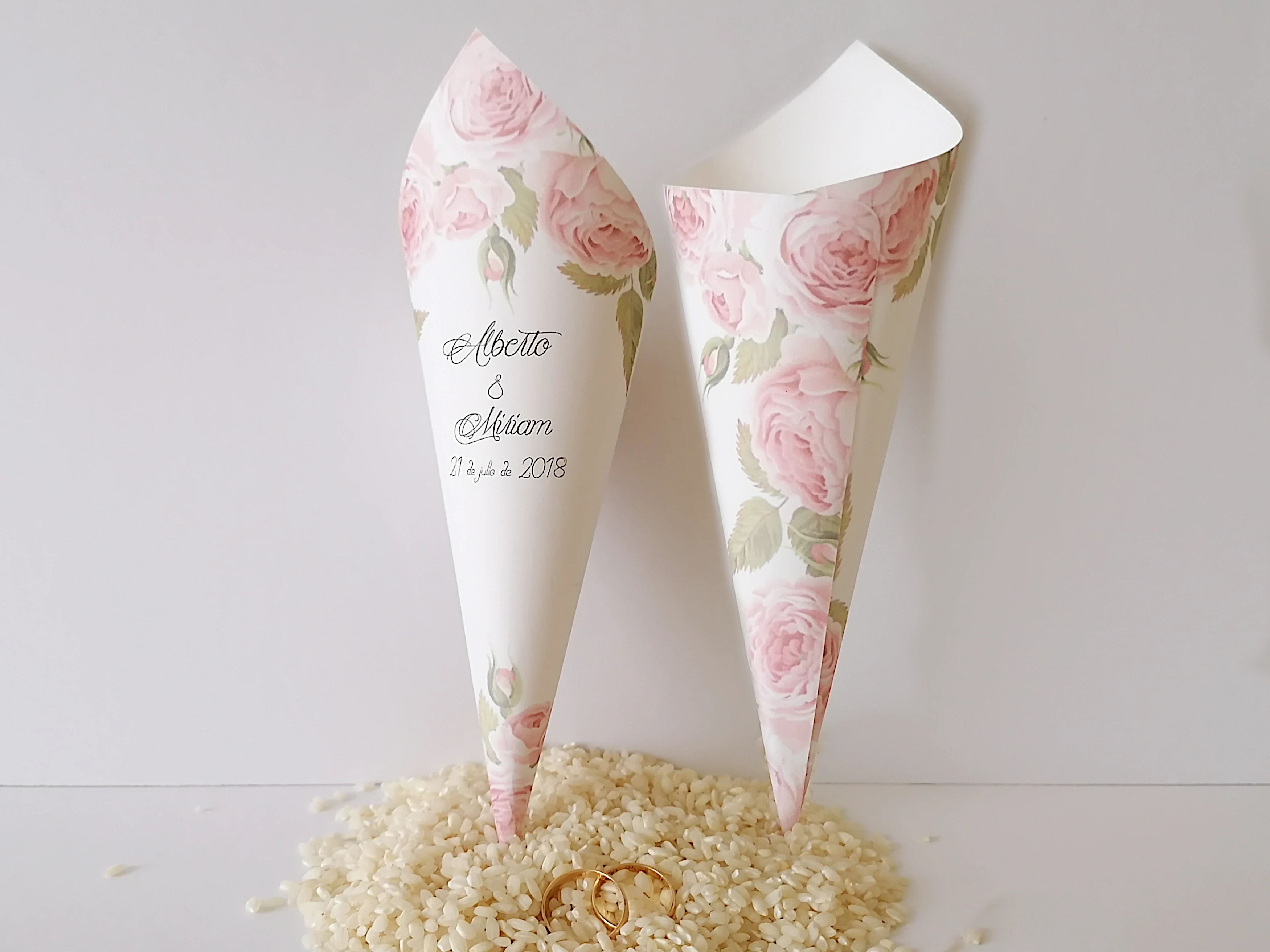 Cono o cucurucho de cartulina de 180gr decorado con un diseño floral de rosas. Están pensados para que los invitados a vuestra boda puedan portar con facilidad el arroz, confeti o pétalos para llenar de color vuestra salida del templo ya como matrimonio.