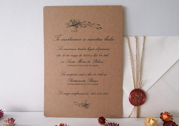 En esta imagen se ve una invitación de boda botánica. El fondo es papel de 300gr blanco roto con textura. Las medidas son 14,8x21cm y sobre este fondo hay un recuadro de papel Kraft de 300gr sobre el que hay pegadas dos amapolas que han sido prensadas y secadas por mi. En la parte superior están impresos los nombres de los novios y en la parte inferior la fecha. Los datos restantes están en el reverso de la tarjeta. También se ve un sobre de papel Kraft adornado con una cuerda y un sello de lacre color rojo.